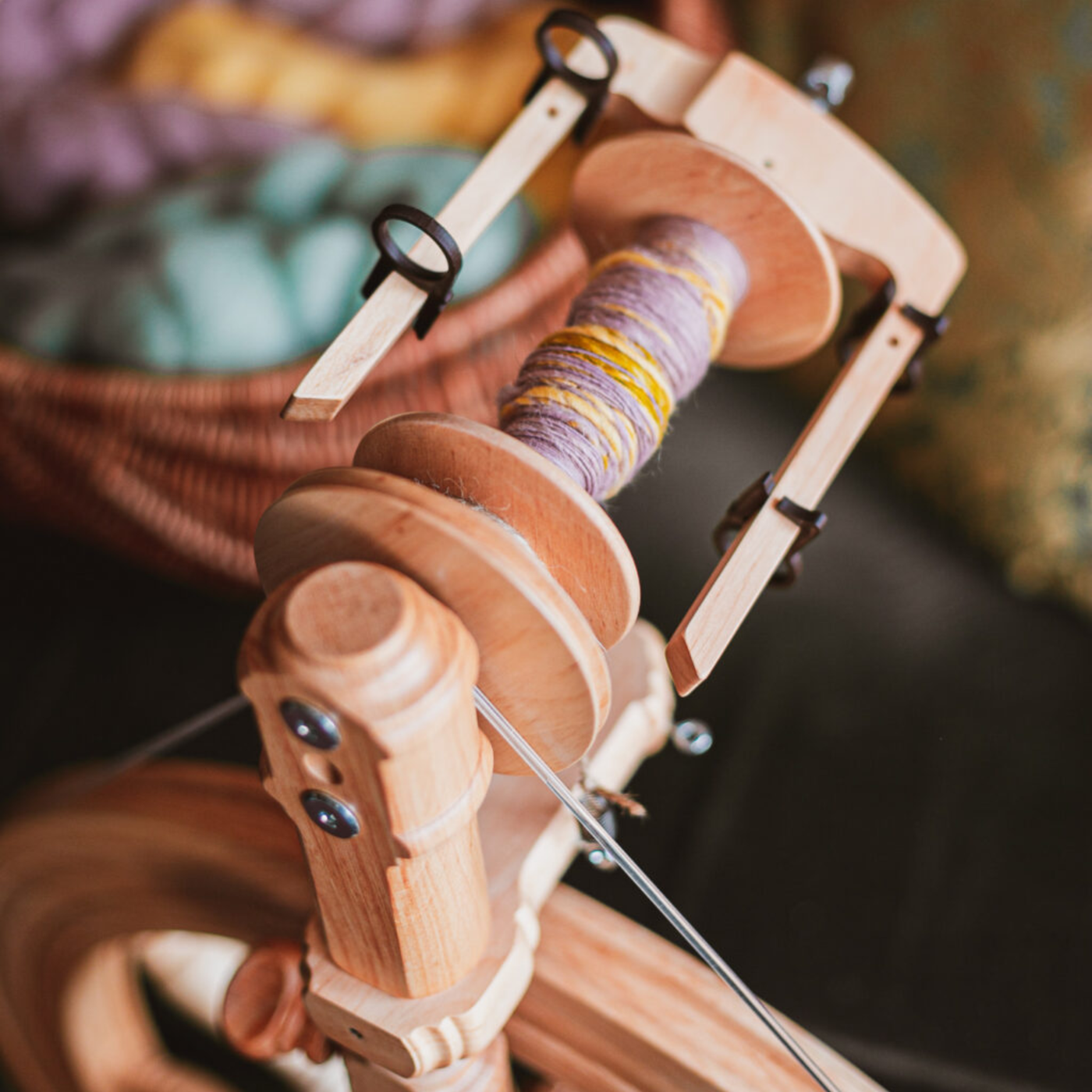 Close-up of Kromski Sonata Encore bobbin and flyer with yarn on the hooks, highlighting scotch-tension style spinning control.