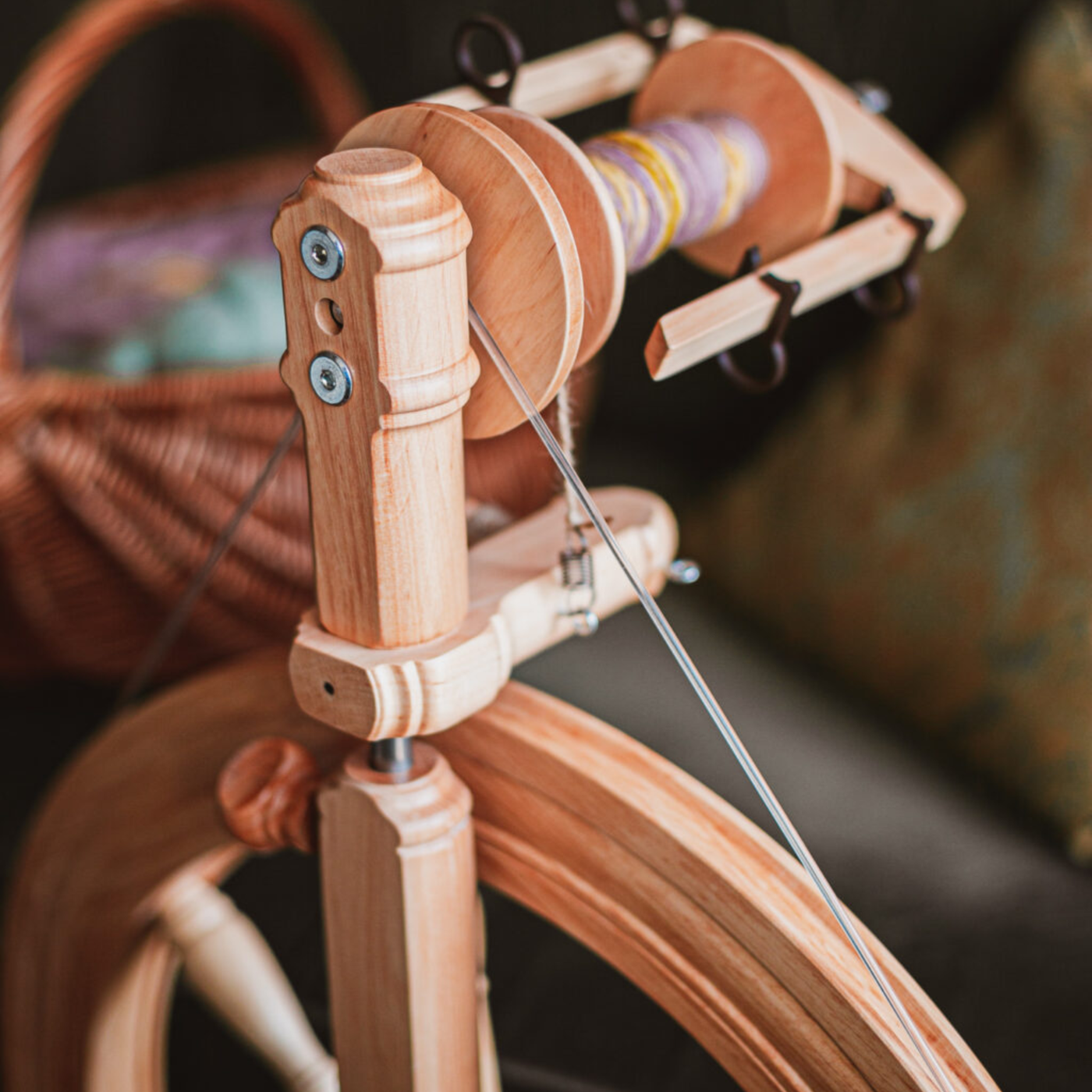 Detail shot of Kromski Sonata Encore flyer, hooks, and orifice with yarn, showing precision hardware and smooth drafting path.