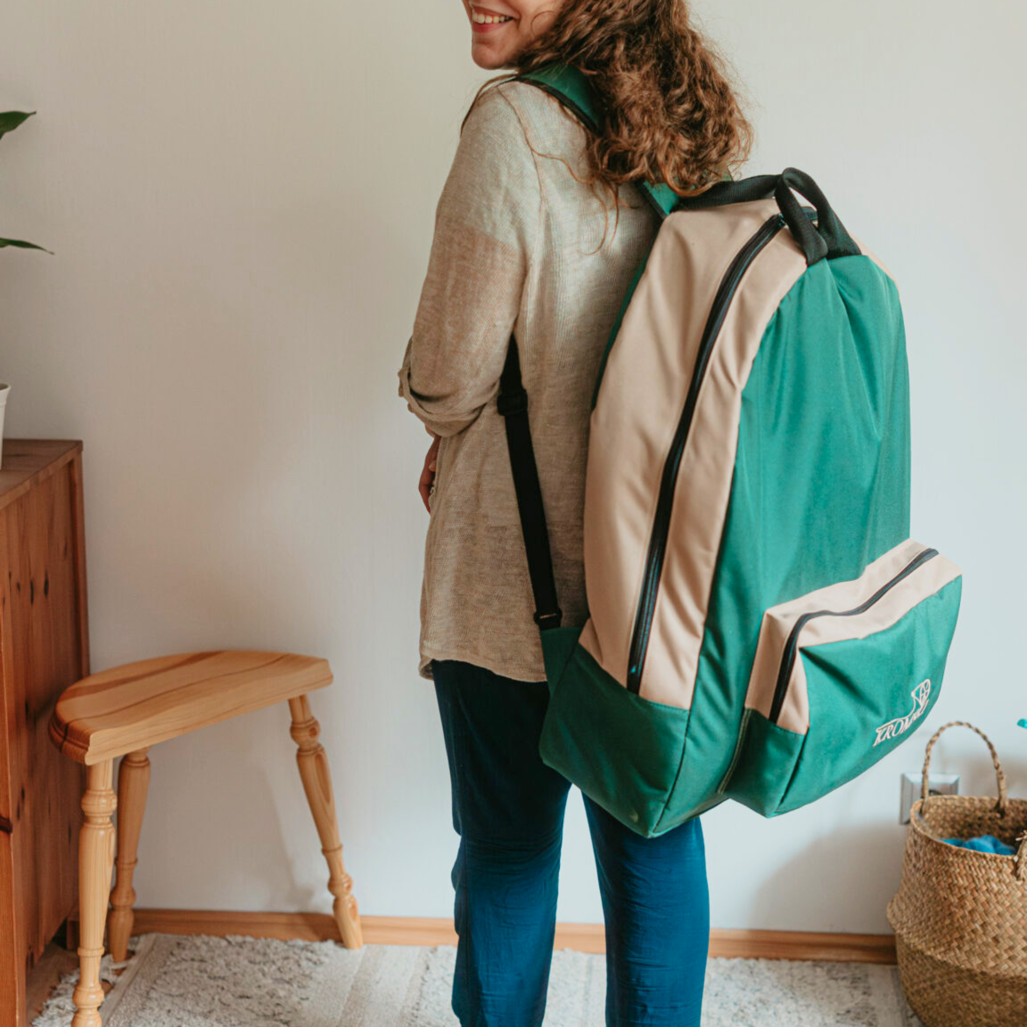Maker wearing Kromski Sonata carry backpack in teal green—easy way to transport the Sonata Encore folding spinning wheel.