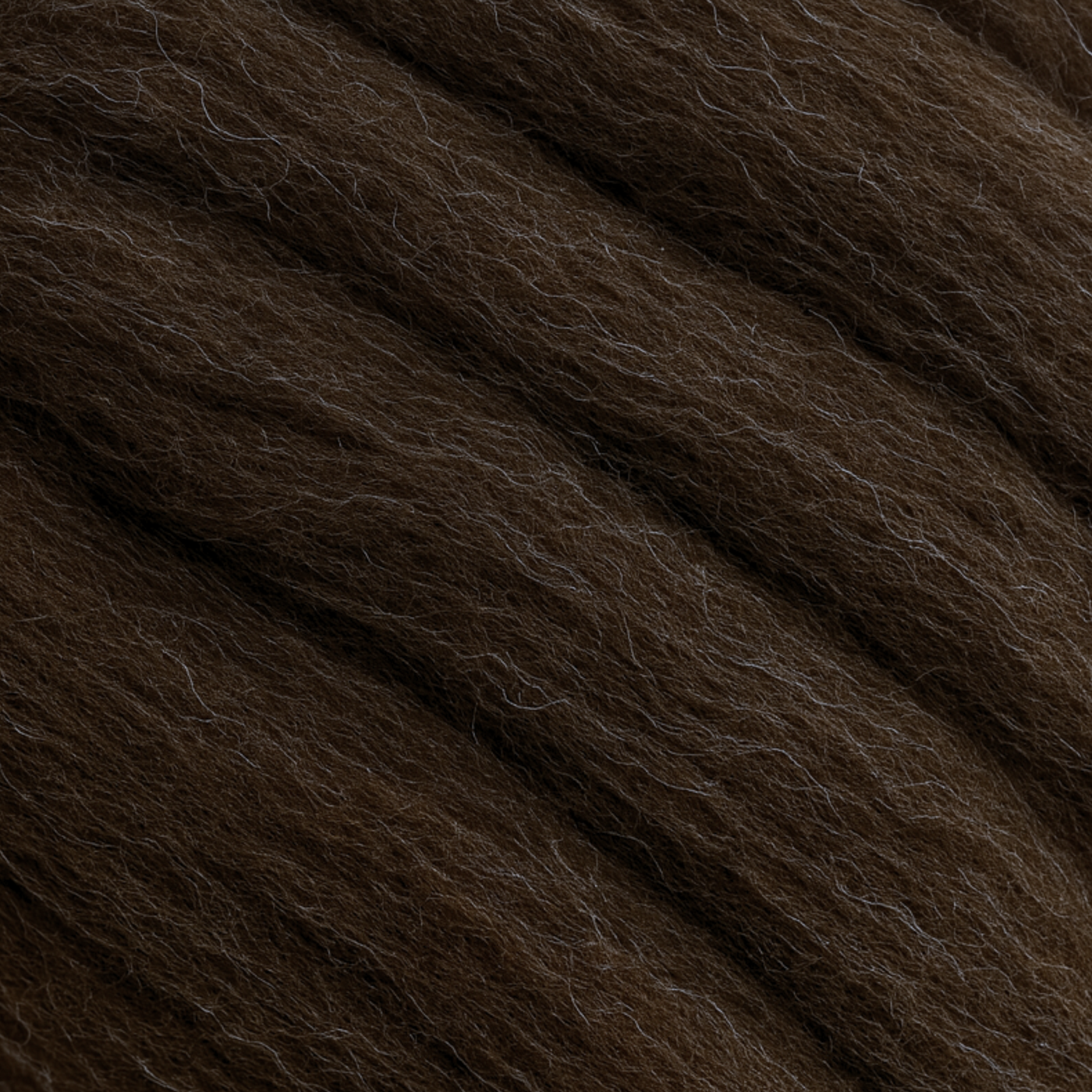 Macro close-up of Corriedale fiber showing uniform crimp and aligned staples—natural brown, 28-micron combed top for smooth drafting.