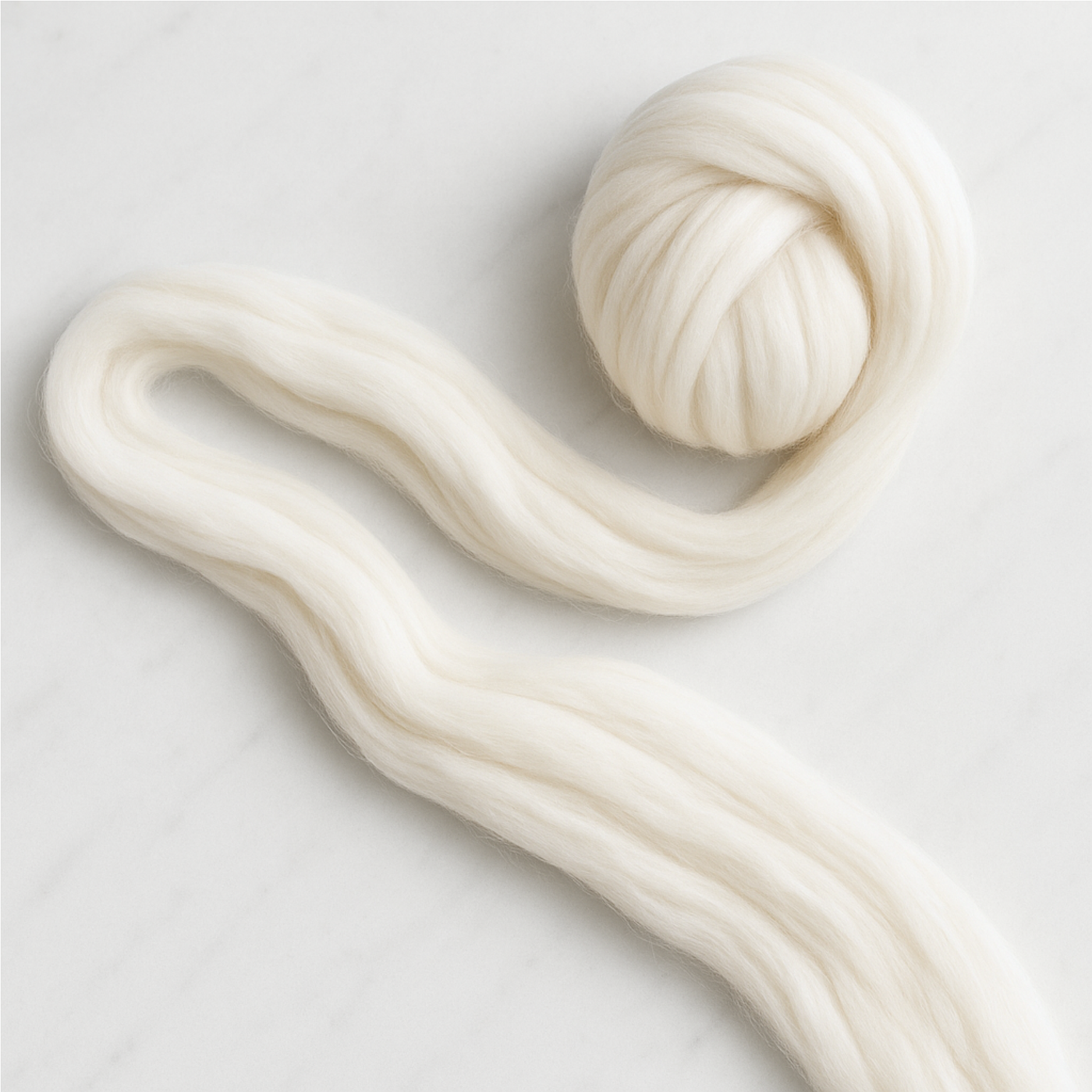 S-shaped length of Merino combed top showing staple and uniform prep—clean, easy-drafting undyed fiber for smooth yarn.