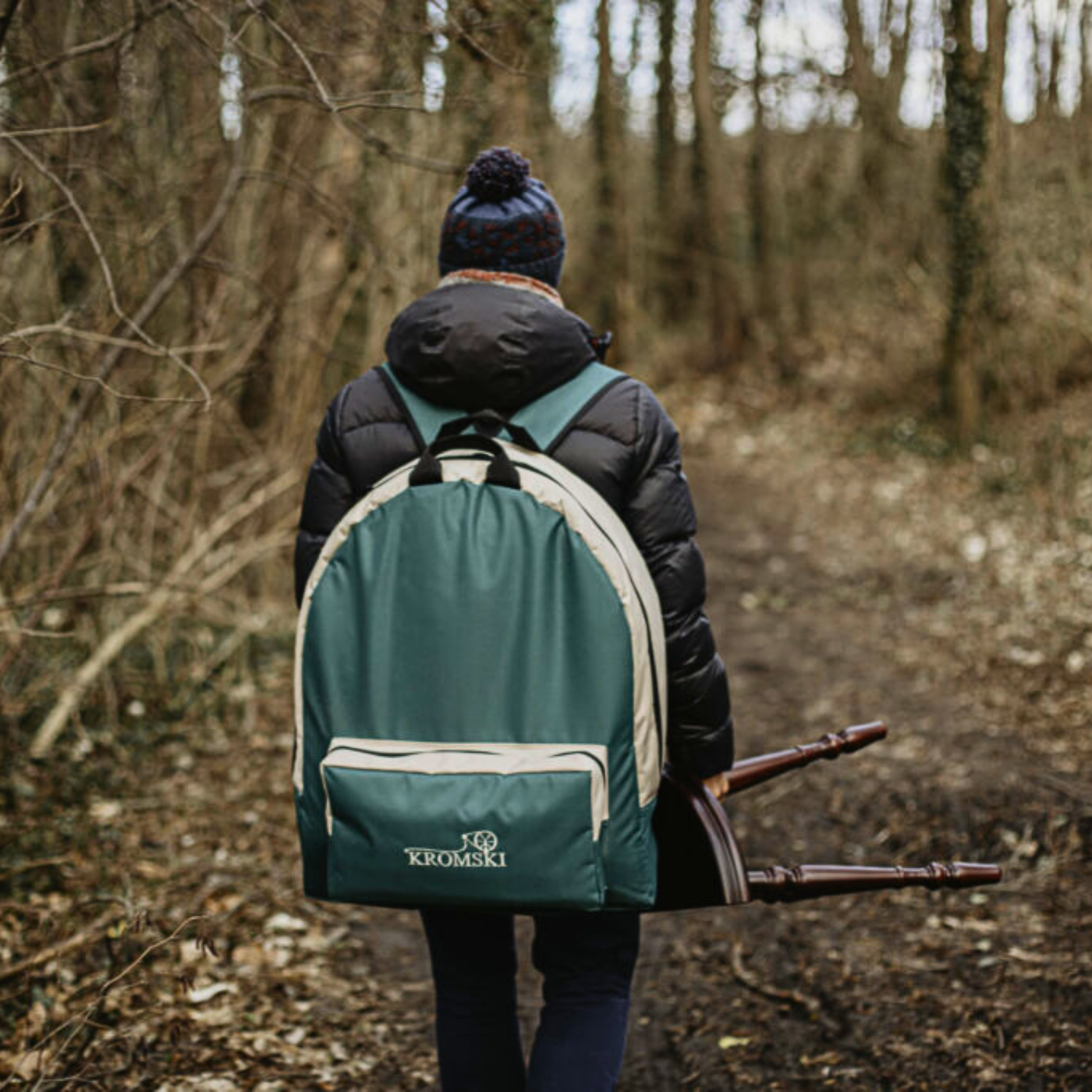 Hiker carrying Kromski Sonata backpack bag on a forest trail, showing the Sonata Encore as a true travel-friendly spinning wheel.