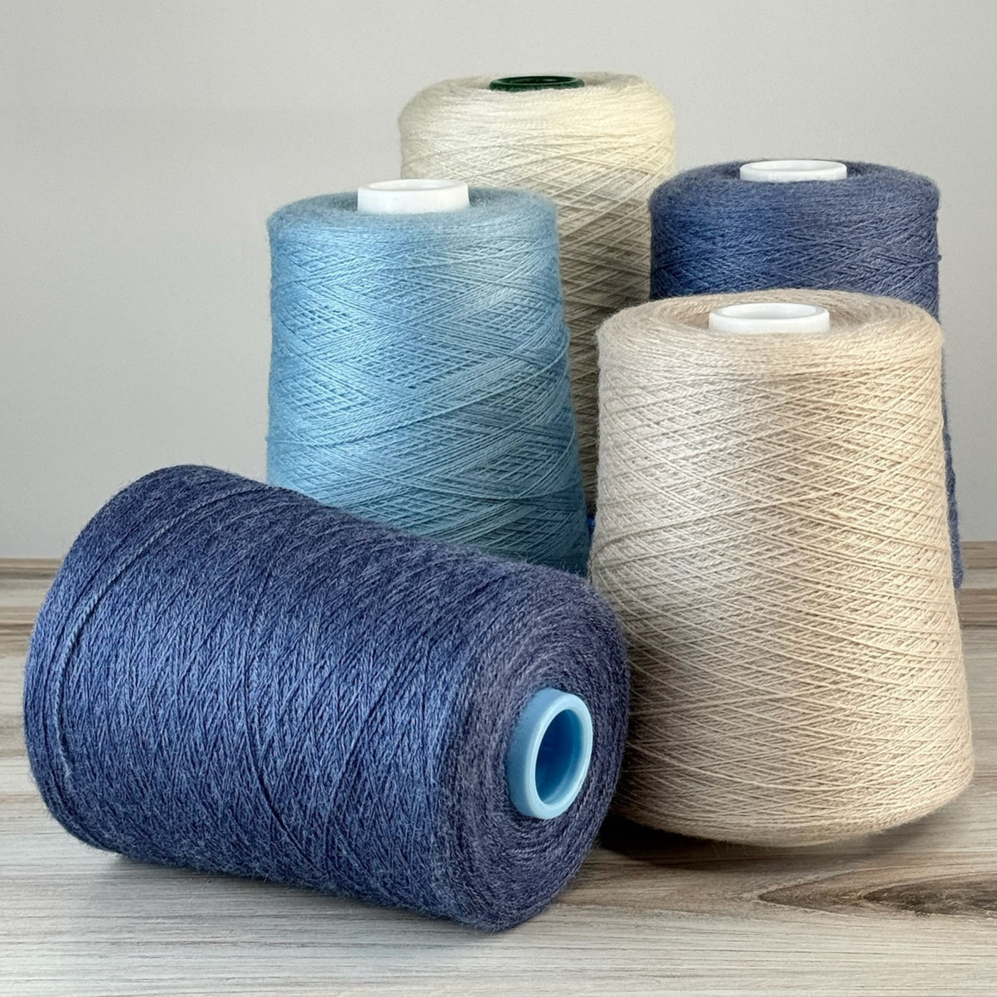Slate and denim cones with a vanilla neutral, one blue rolled forward; 1 lb. cones, 2/18 lace, 4455 yards—versatile for weft accents.