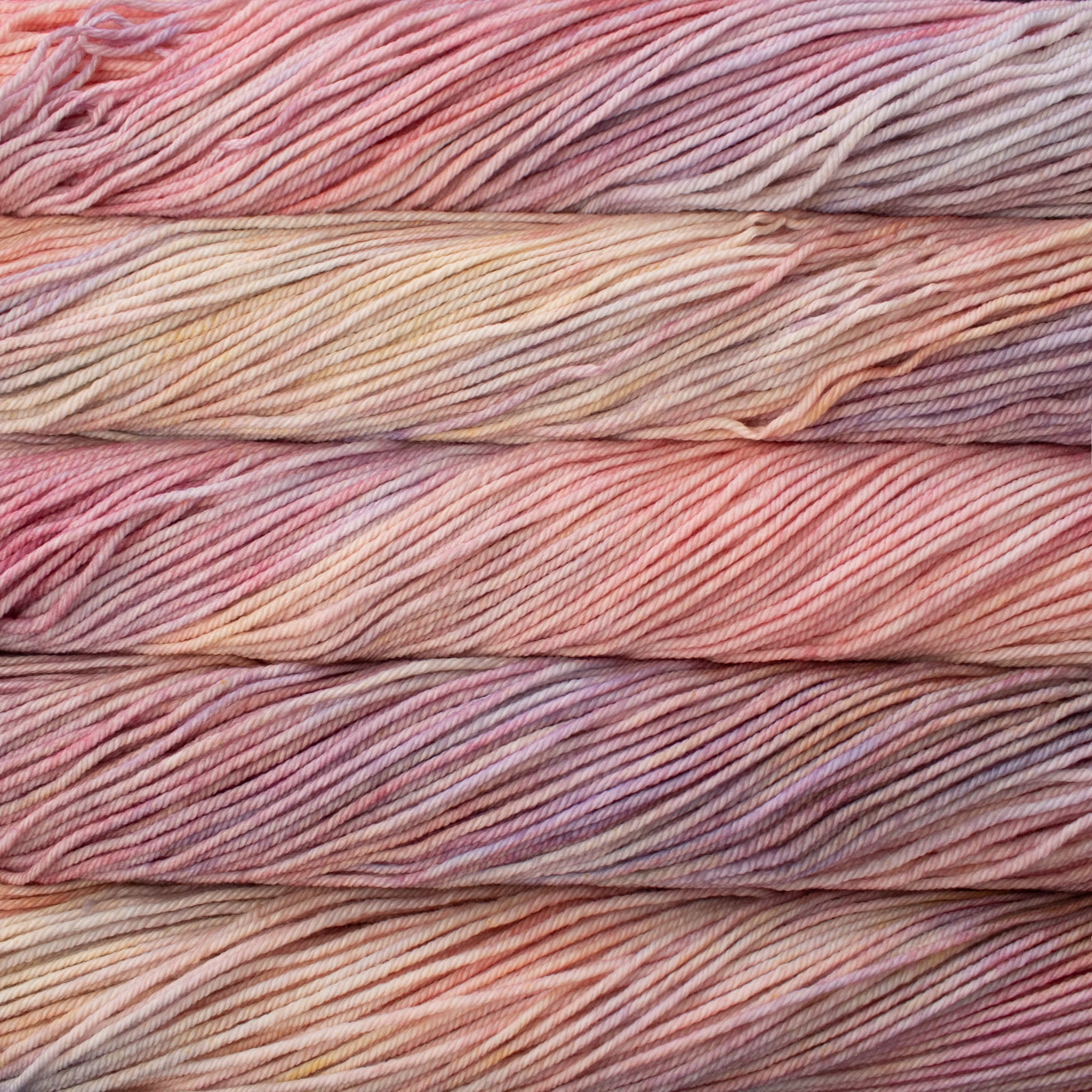 Malabrigo Rios hand-dyed worsted yarn in Rosalinda RIO398, with cream, blush, peach, lavender, and pale gold.