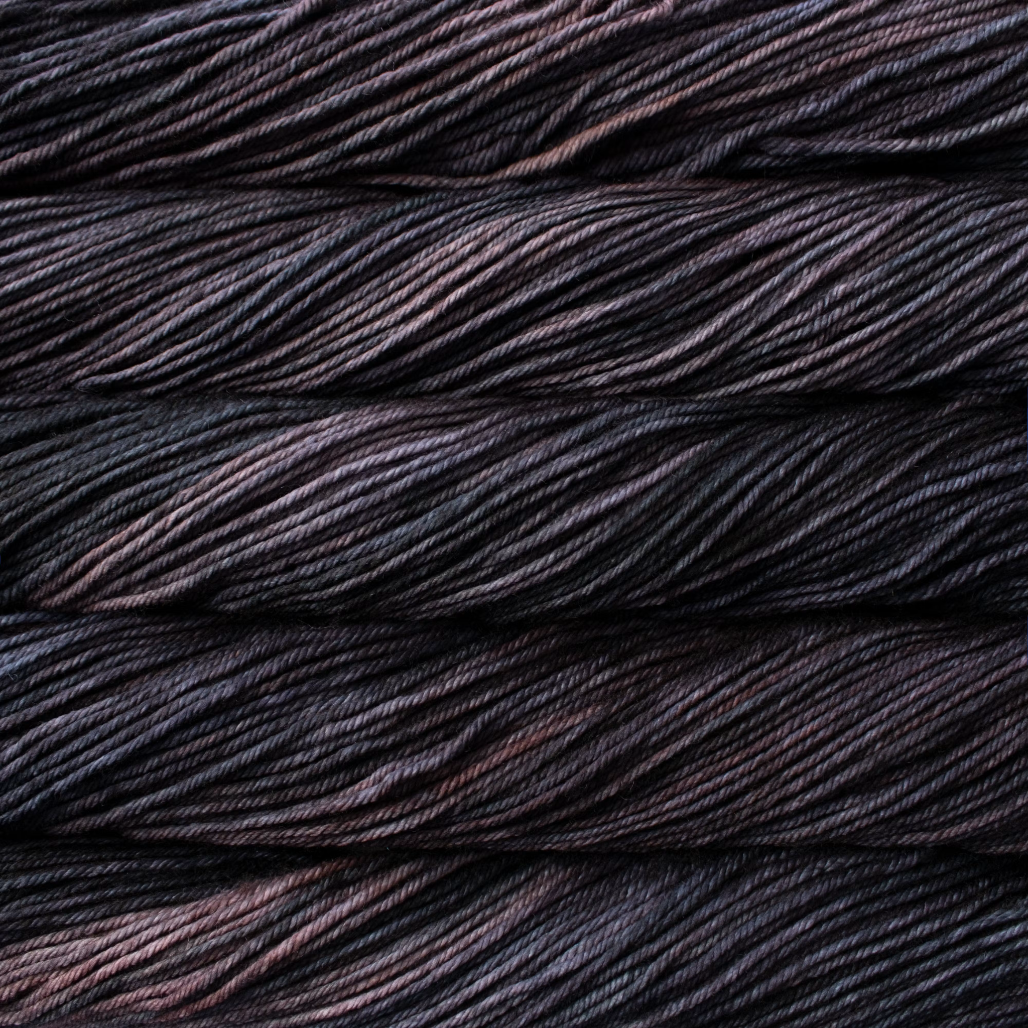 Malabrigo Rios hand-dyed worsted yarn in Scorpio RIO285, with charcoal, near-black, plum, and brown tonal variation.