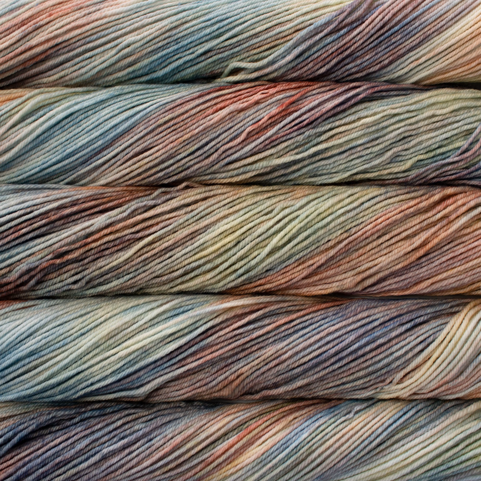 Malabrigo Rios hand-dyed worsted yarn in Zahara RIO267, with muted teal, peach, tan, gray, and soft blue tones.