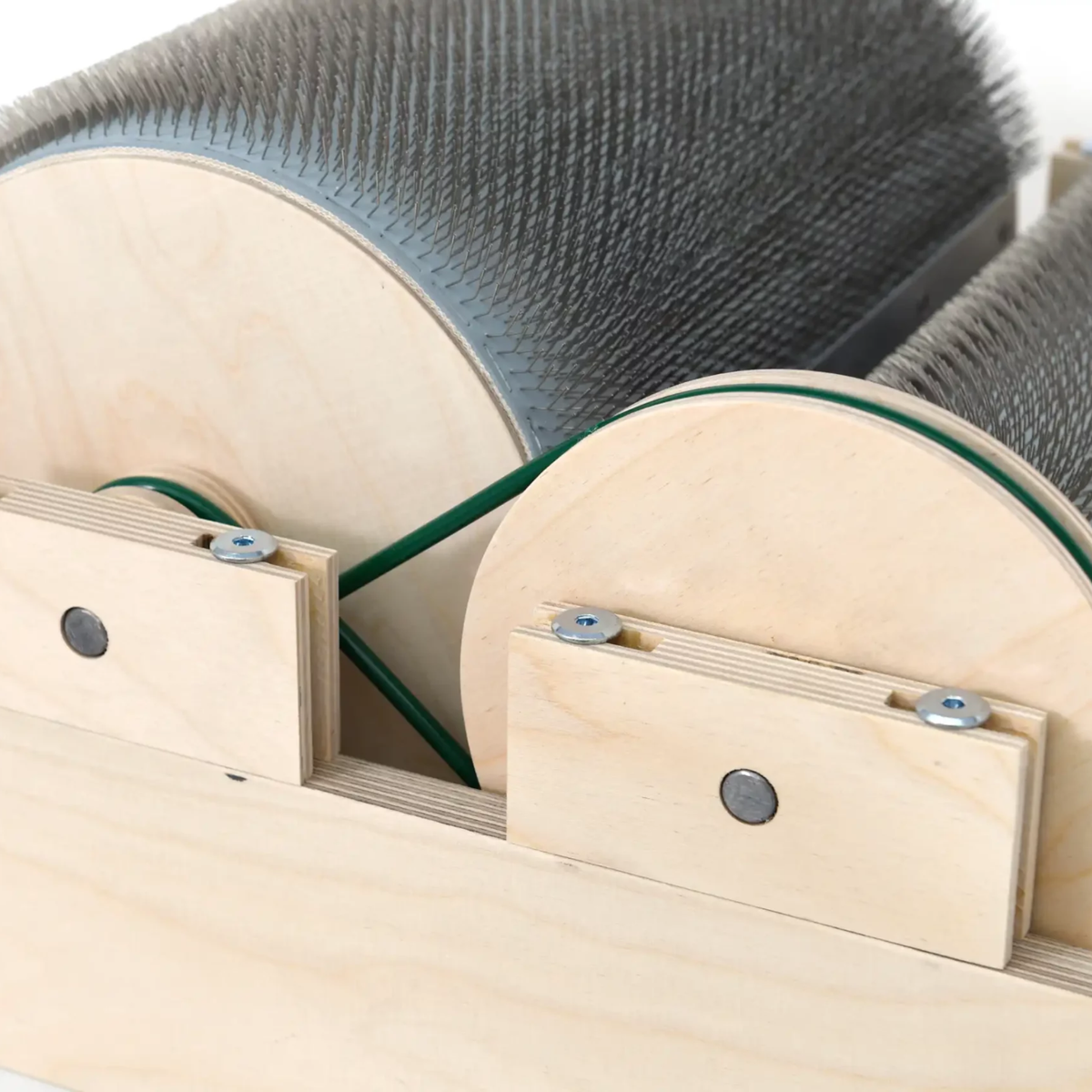 Drive-side detail of the Golden Fleece WIDE 54 TPI drum carder showing the drums, wooden frame, and belt system.