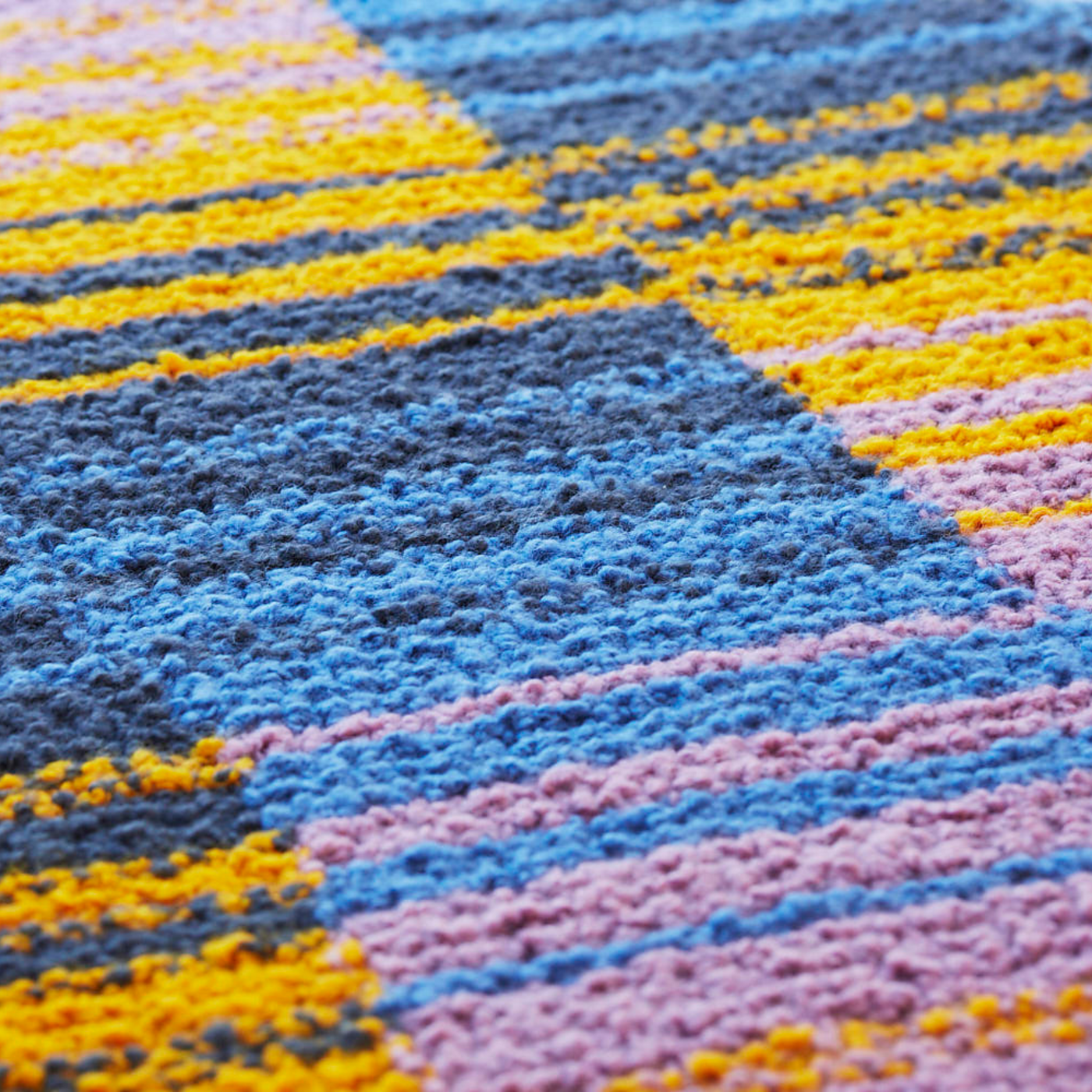 Finished close-up of Accoloration Blanket in the colorway Golden Hour- with garter stitch and intarsia using Lanalpaca yarn.