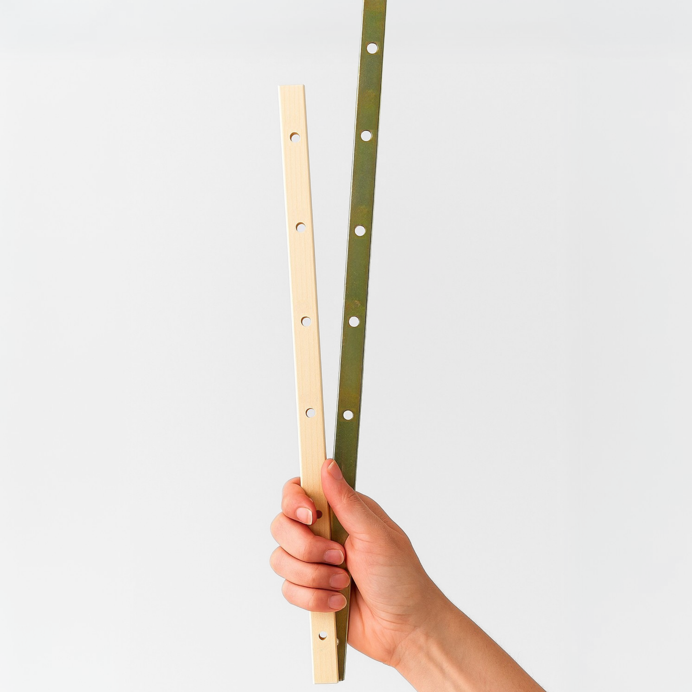 Caucasian hand holding Leclerc metal and wooden beam sticks upright—essential loom accessories for securing warp threads during warping.