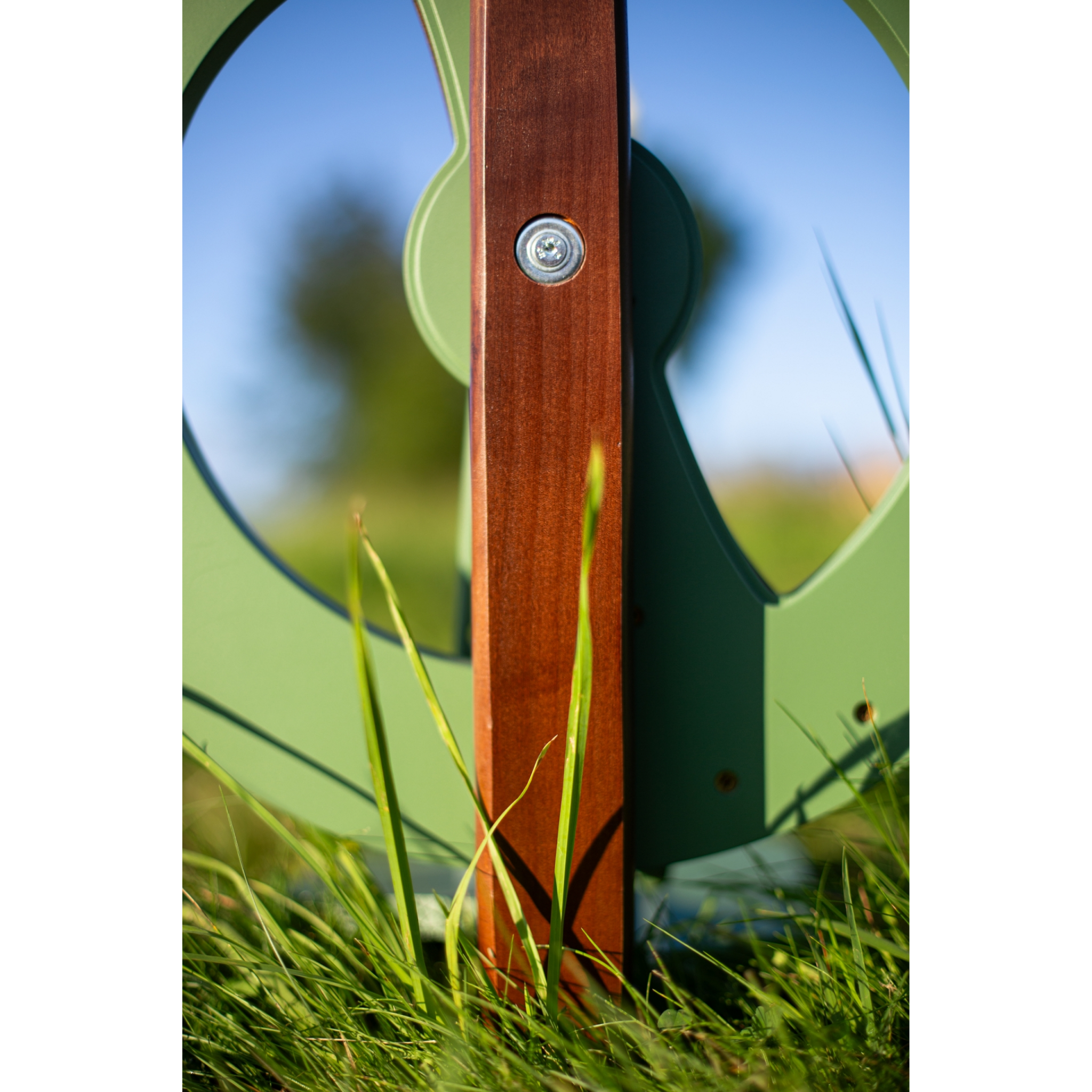A macro view of the backside of the limited edition Kromski Fantasia in meadow green with walnut accents. Placed outdoors in a meadow setting.