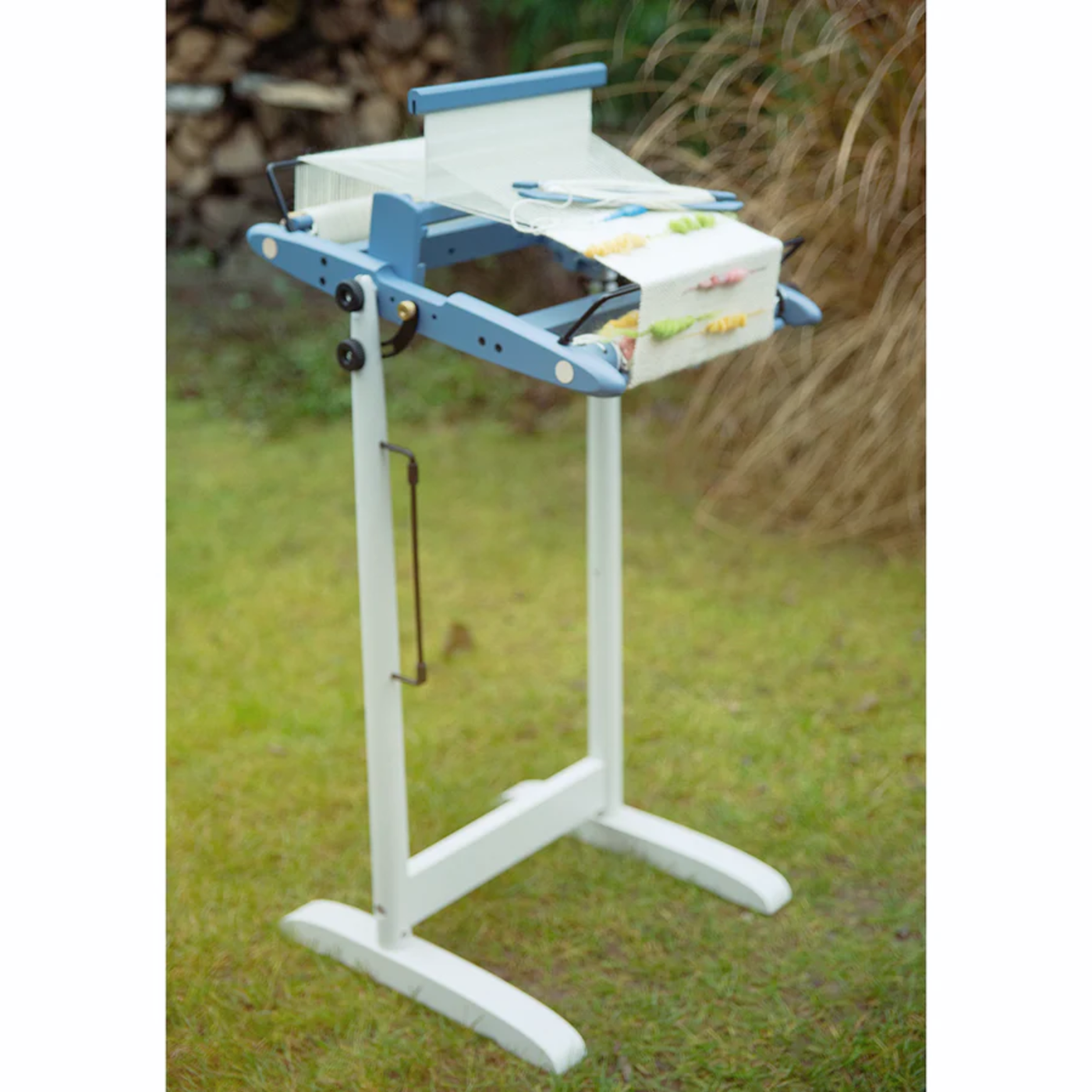 A 10" Kromski Presto Rigid Heddle Loom in the limited edition Harbor Blue colorway on a stand with warp for outdoor weaving.