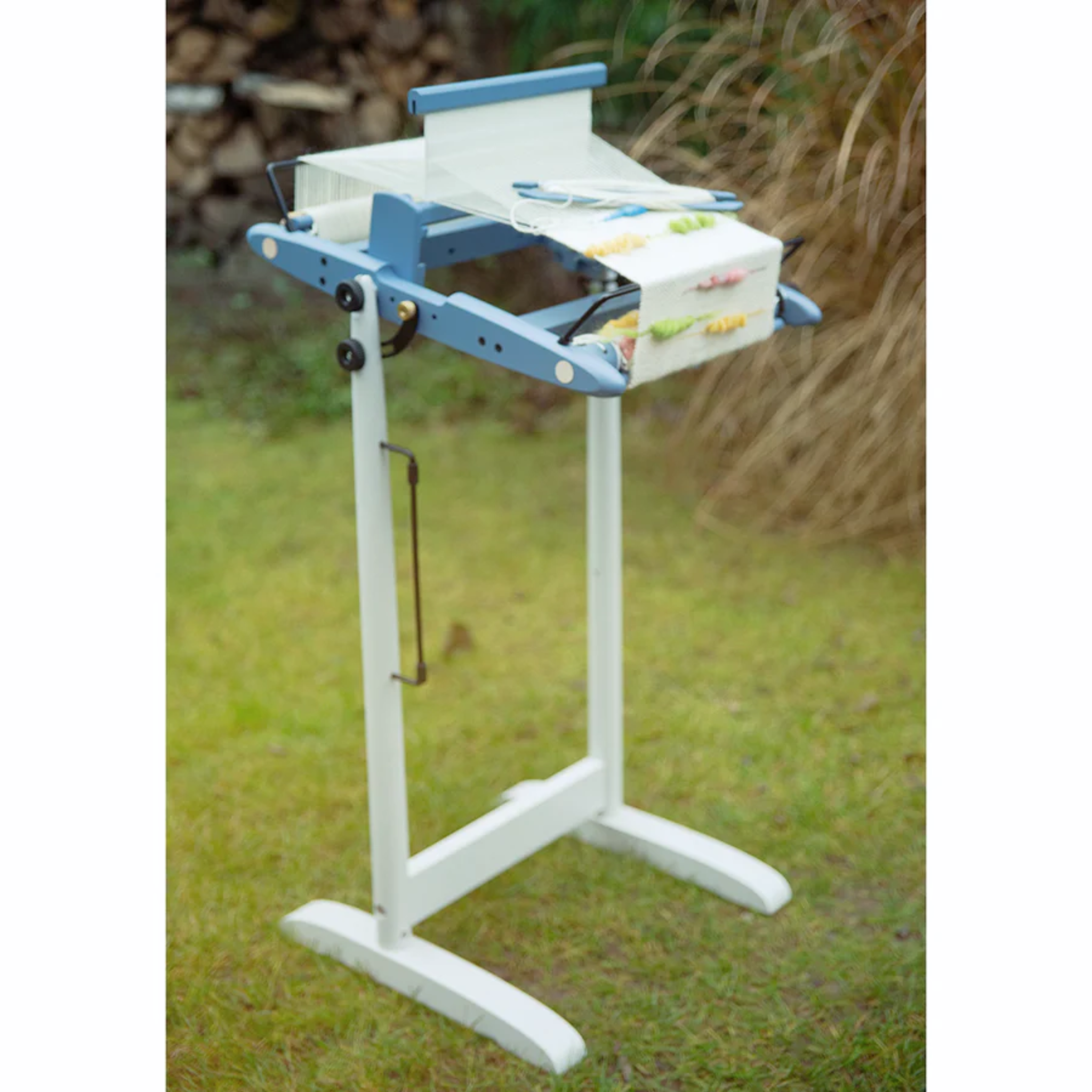 A 10" Kromski Presto Rigid Heddle Loom in the limited edition Harbor Blue colorway on a stand with warp for outdoor weaving.