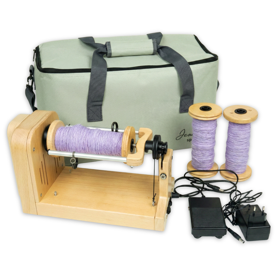 The louet Jenn-E E-Spinner with carrying bag and 3 bobbins of freshly spun lavender yarn.