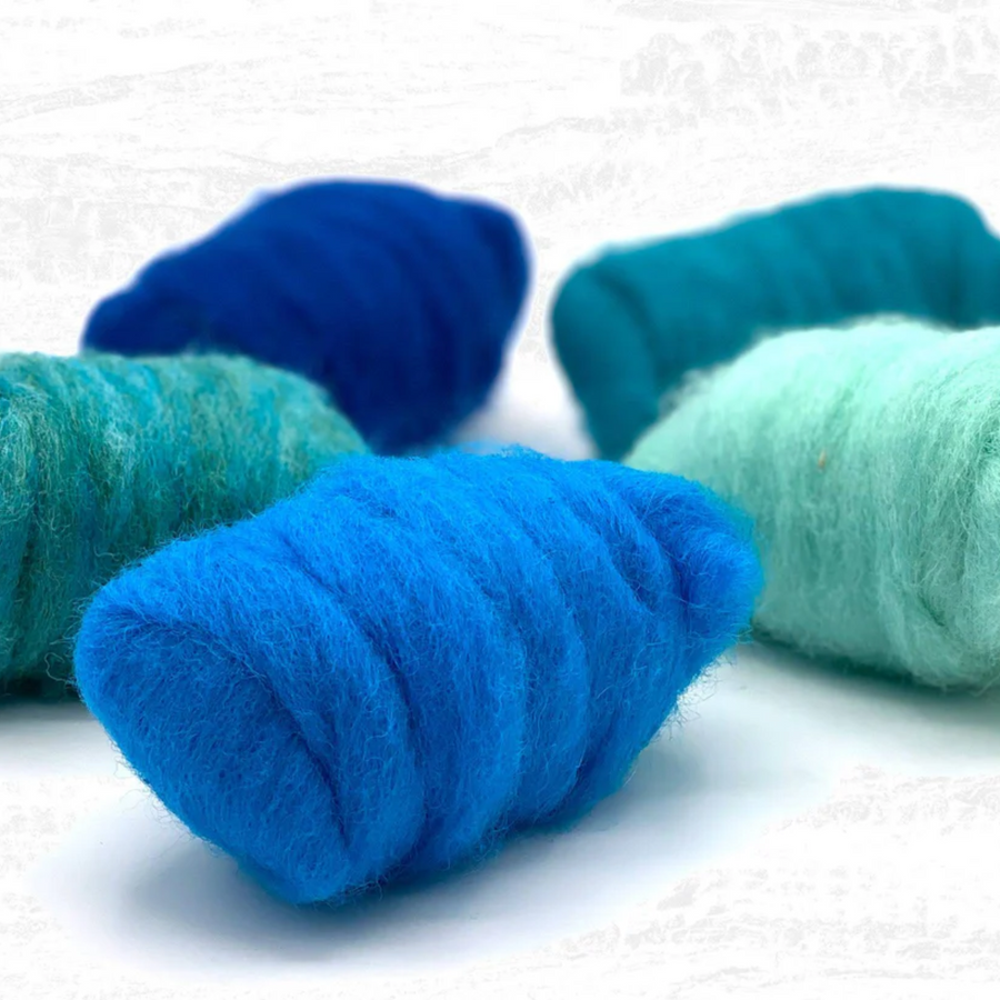 Artistic arrangement of Revolution Fibers Ocean Blues Corriedale Wool Sliver Pack with all five color rolls displayed in a modern, angled layout for fiber art inspiration.