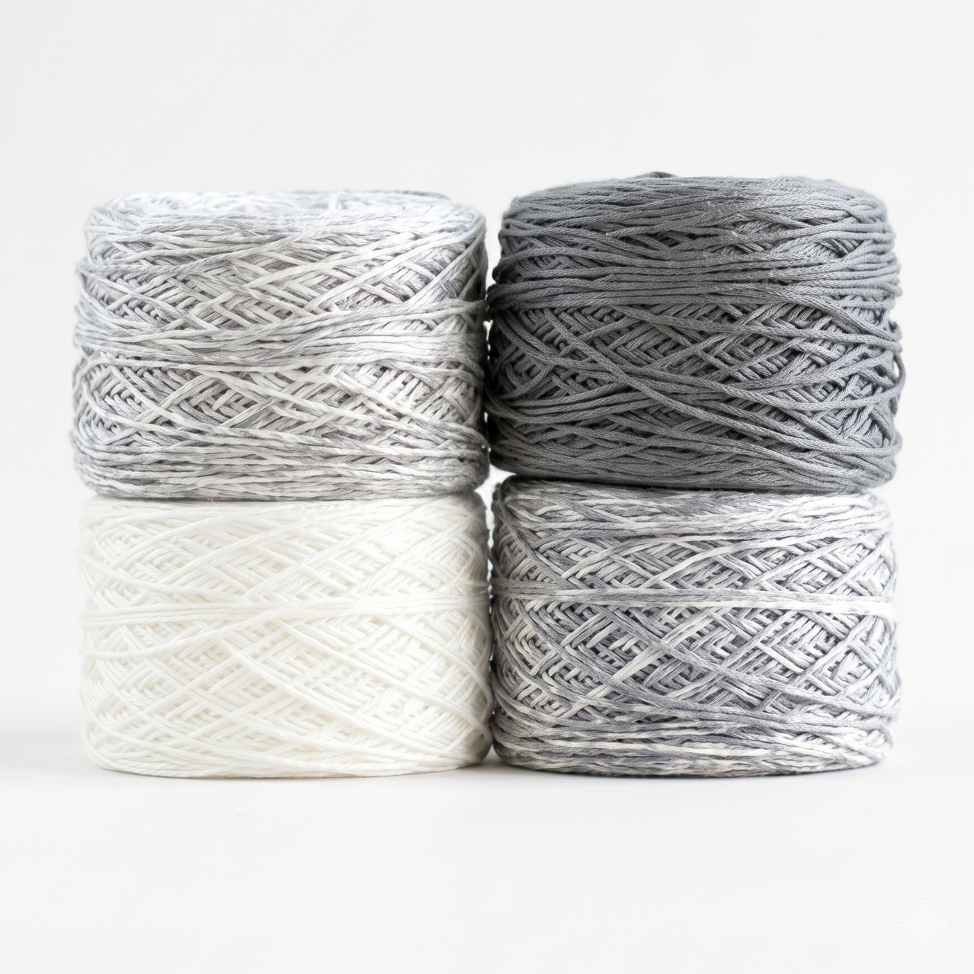 Revolution Fibers Baby Bloom Gradient Baby Blanket Kit Helios Gray yarn cakes in white, gray speckle, and solid gray.