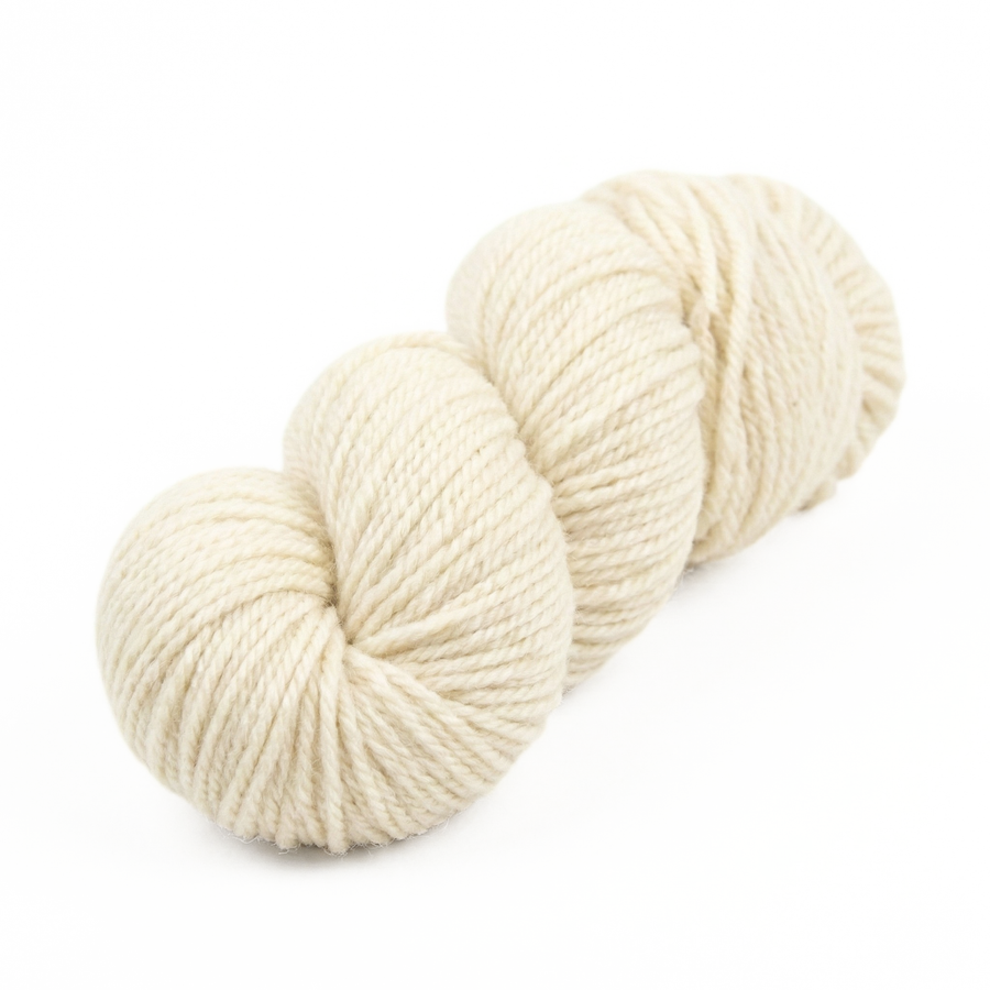 Undyed Blue Faced Leicester (BFL) worsted weight yarn skein, natural cream longwool fiber, clean studio hero on white.