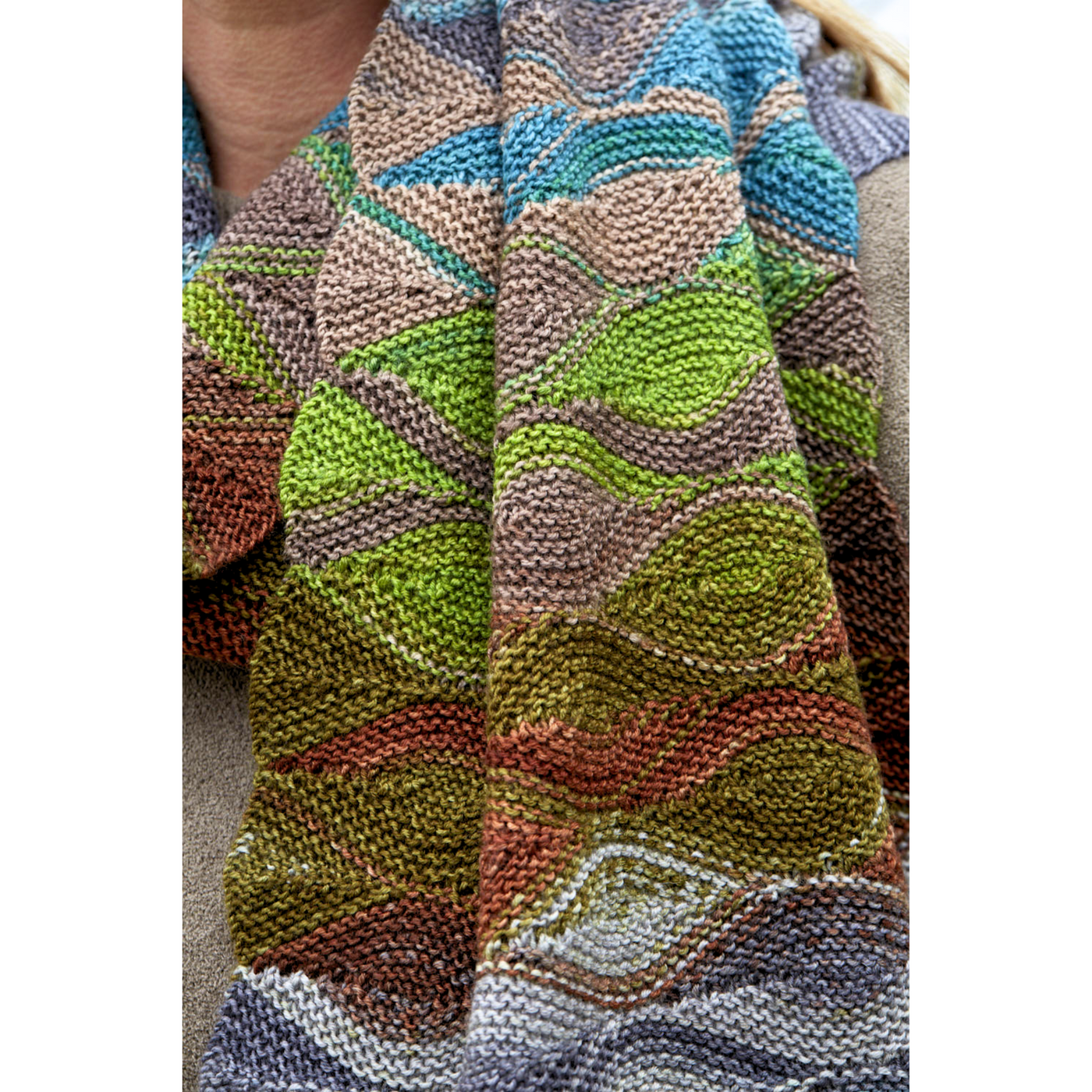Close-up of Hera Scarf fabric in Uneek 3030, highlighting short-row waves and green–blue–brown color transitions.