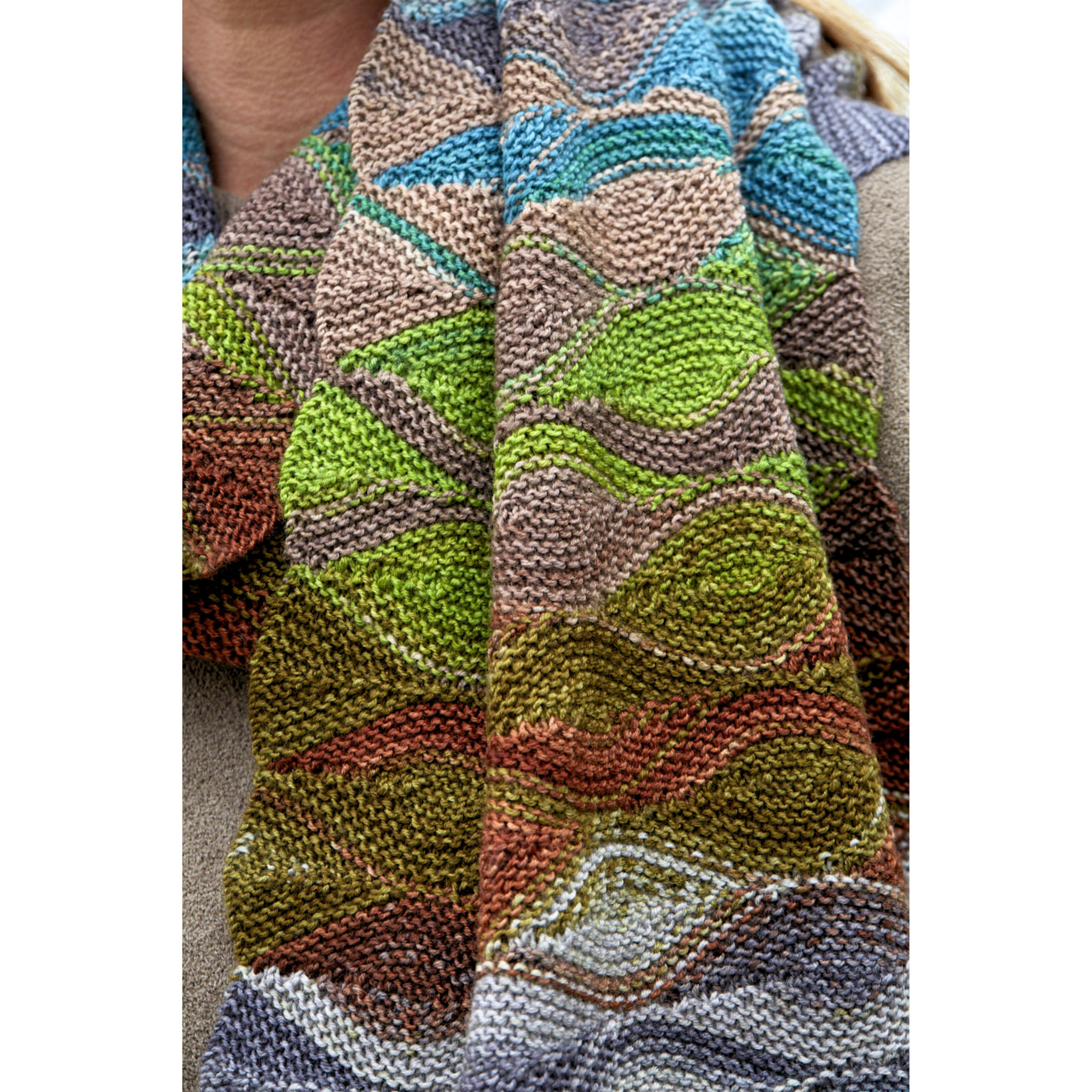 Close-up of Hera Scarf fabric in Uneek 3030, highlighting short-row waves and green–blue–brown color transitions.