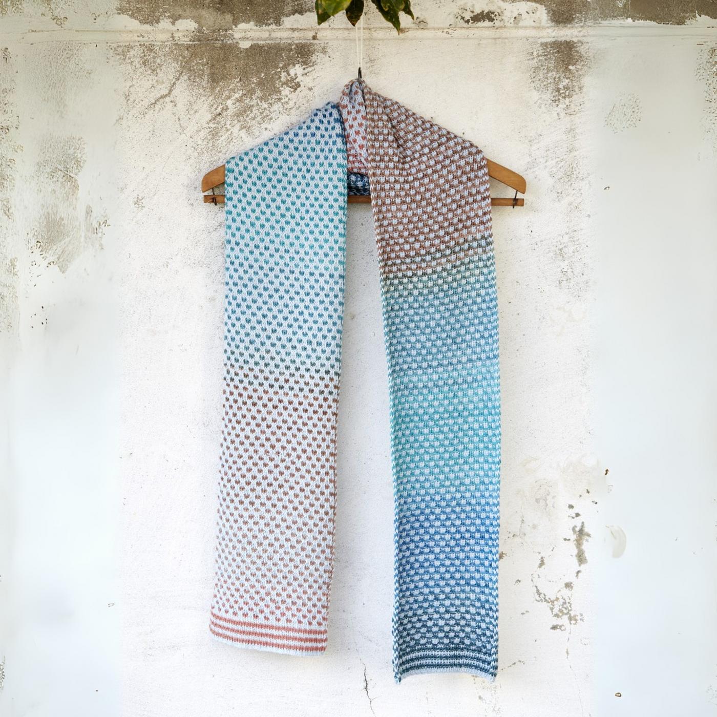 Full-length Saman Scarf in Urth Yarns Echoes 1529 (clay-rose fade) and Core 1011 (sky-blue) hanging to display gradient color shift and tidy I-cord edges.