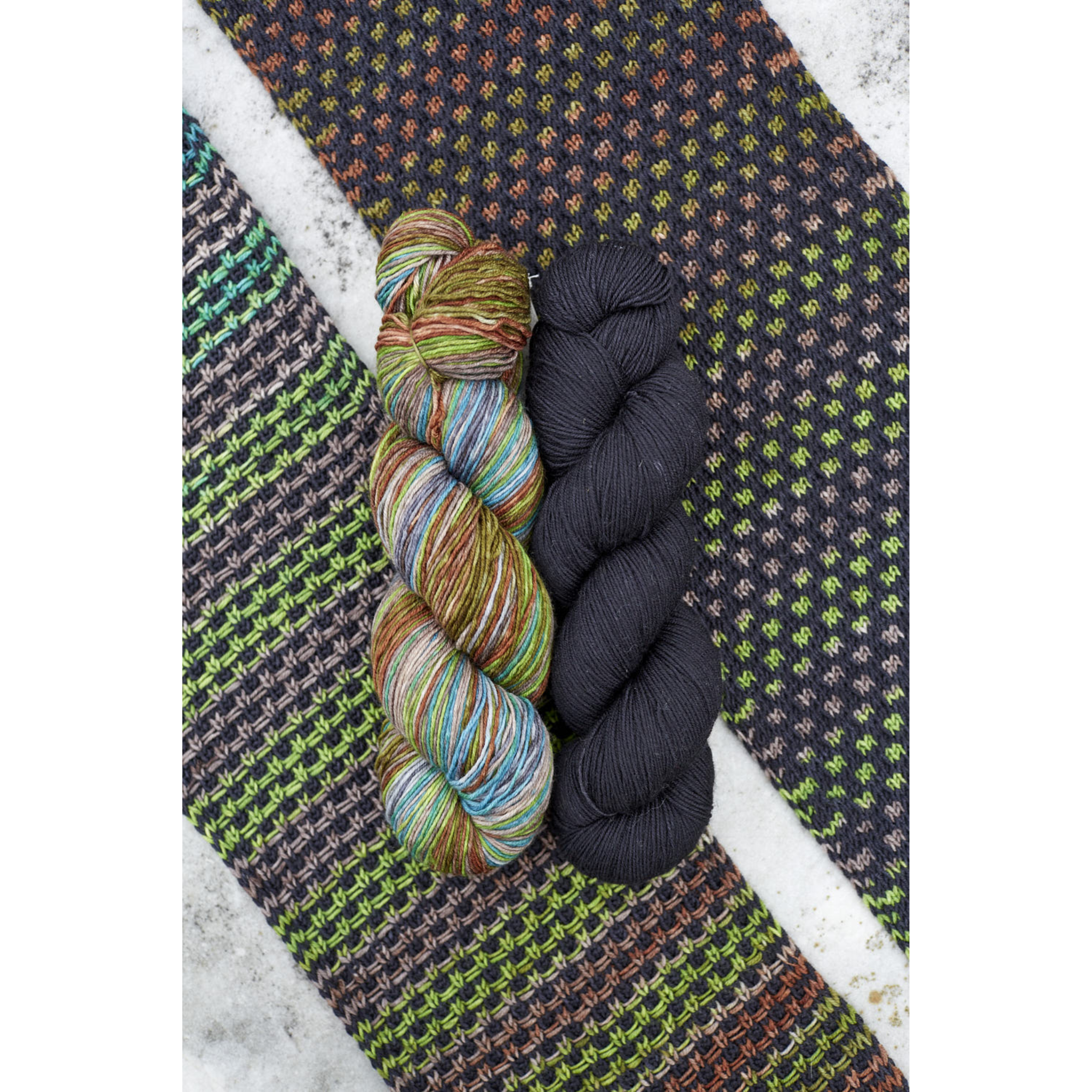 Forest‑inspired Saman Scarf kit swatch featuring Uneek 3030 variegation with deep green Harvest Thuja solid.