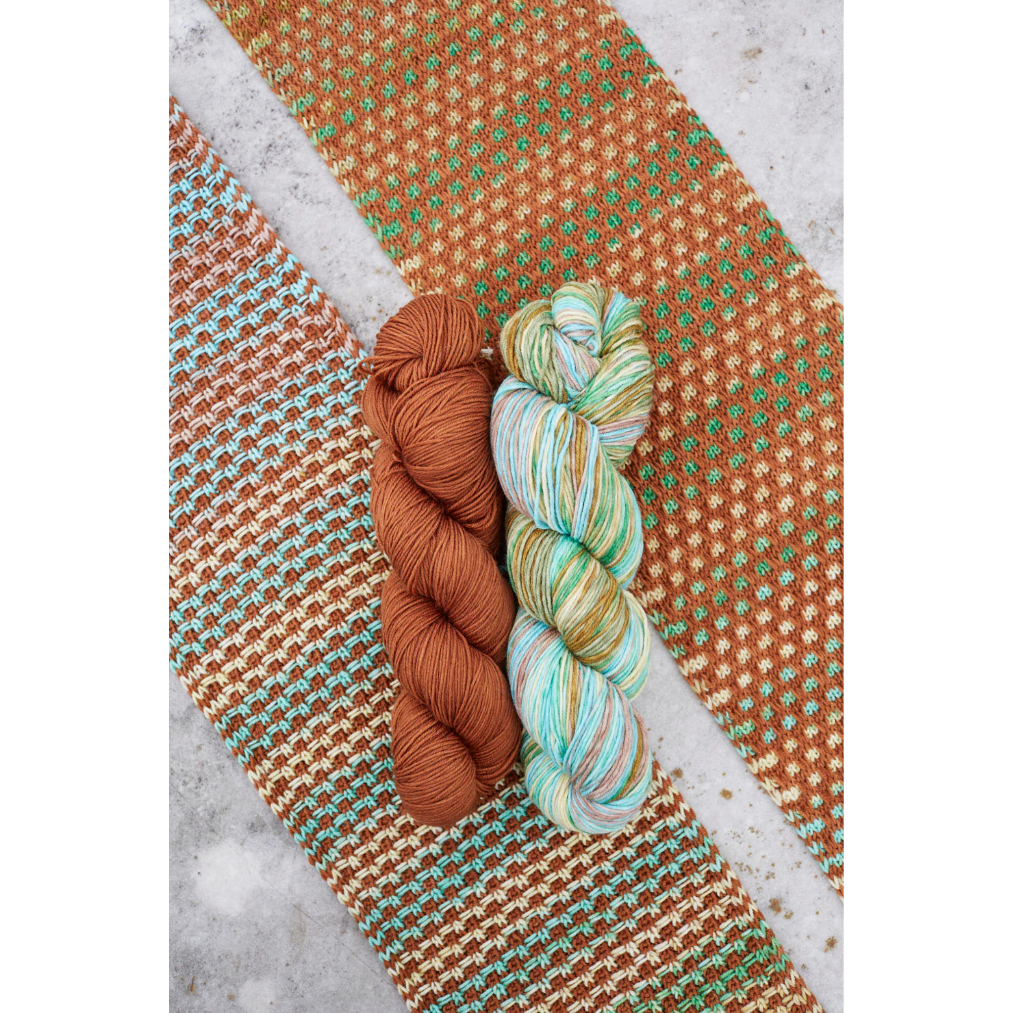 Swatch and skeins combo of Uneek 3034 and Harvest Cinnamon for the Saman Scarf kit, showing rich autumn tones.