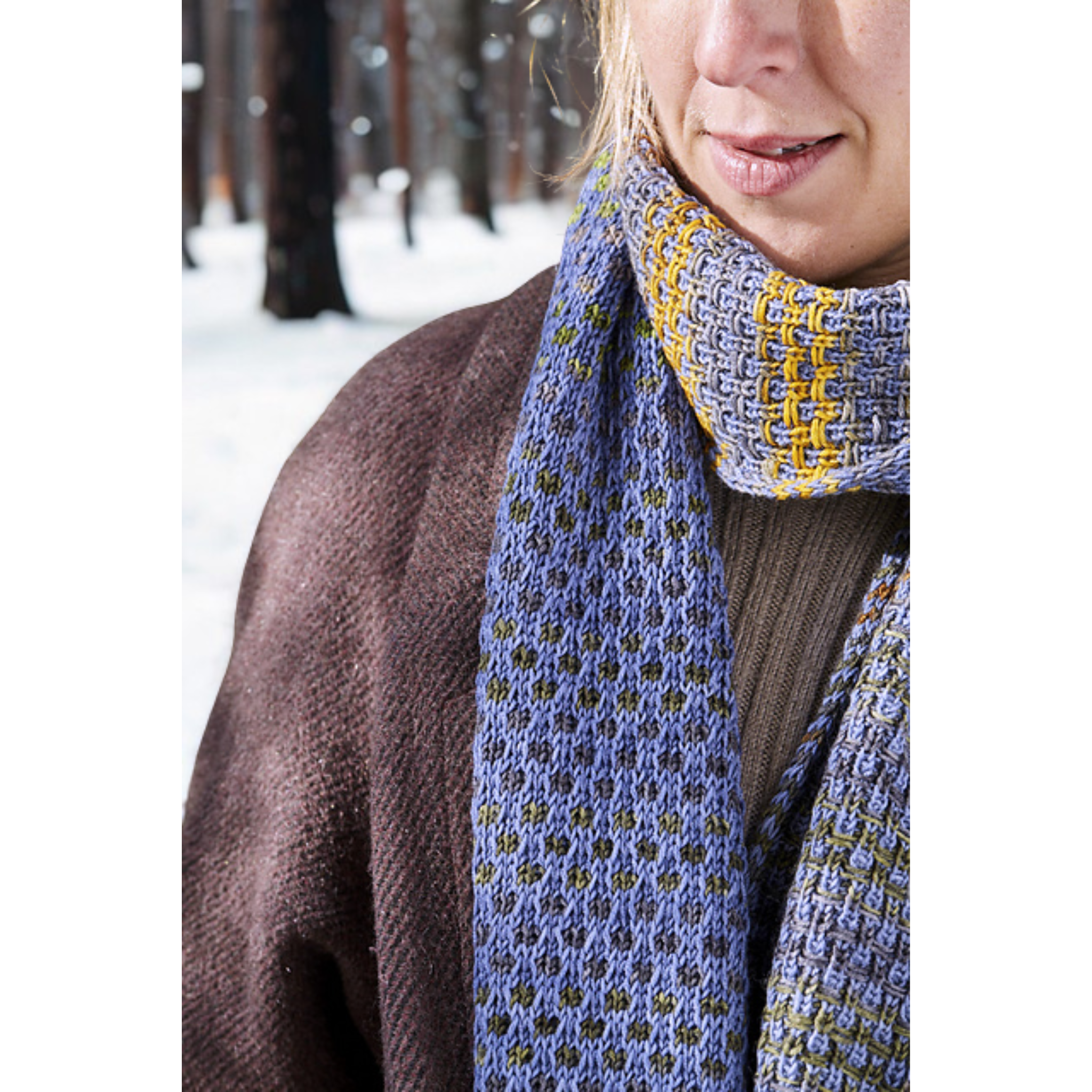 Neck detail of the Saman Scarf on a model, featuring Urth Yarns Uneek 3001 stripes against Harvest CPC solid.