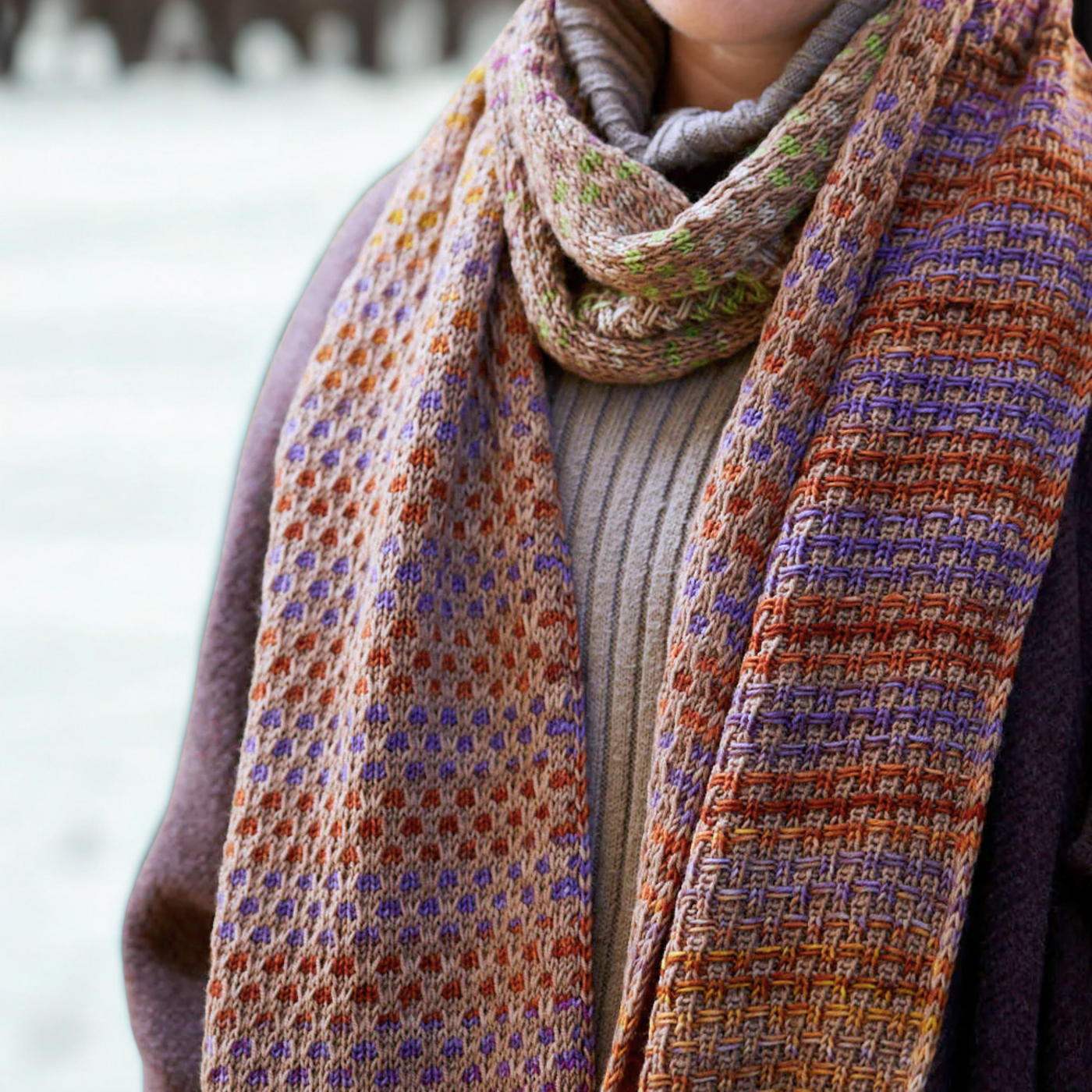 Saman Scarf looped around the neck in Uneek 3029 and Harvest Walnut, emphasizing reversible slip‑stitch dots and drape.